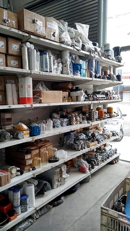 Estantería con cabezales, vasos, carcasas y componentes para filtración
