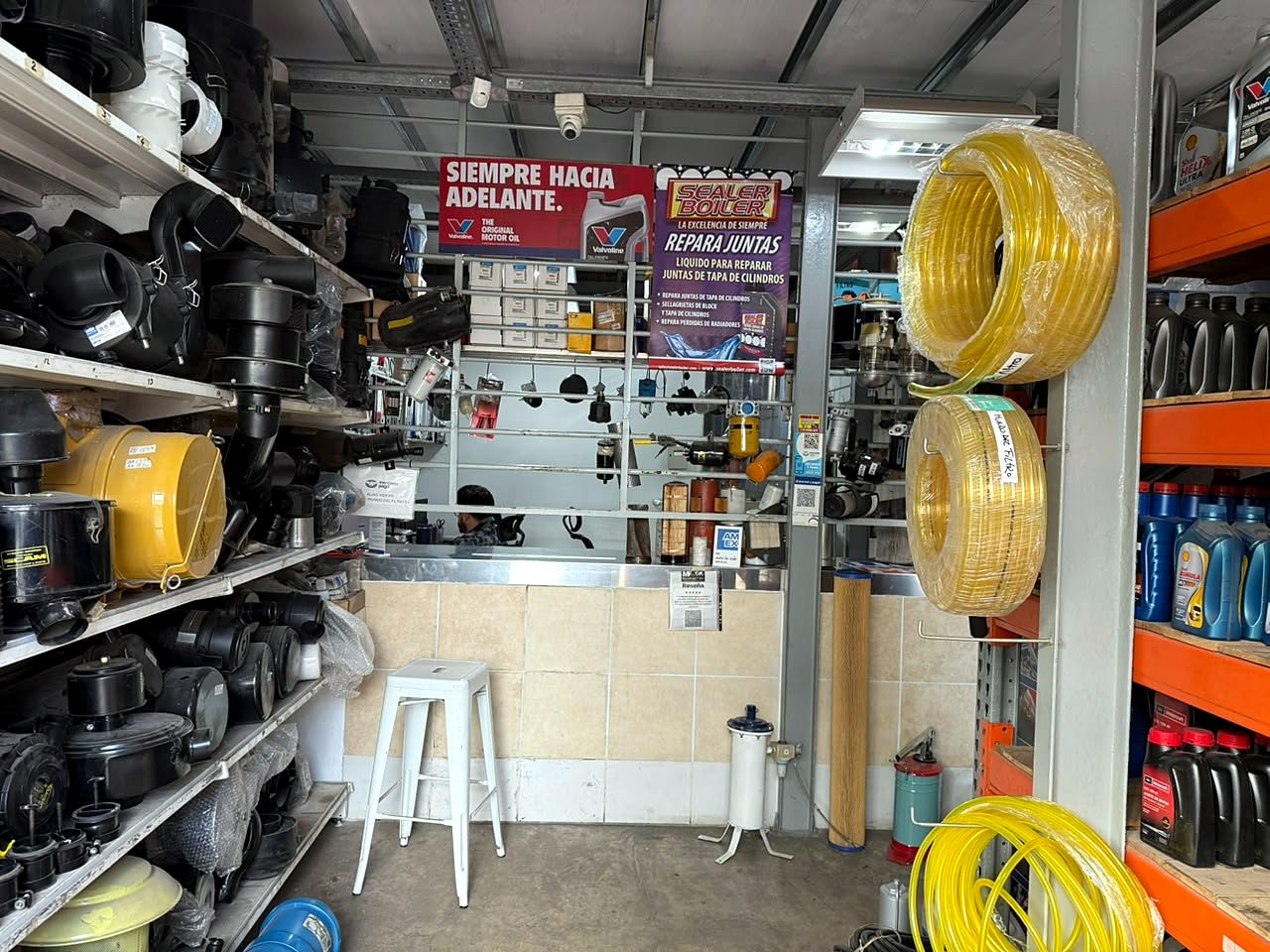 Mostrador de atención en Morón con carcasas de filtros de aire, mangueras y lubricantes